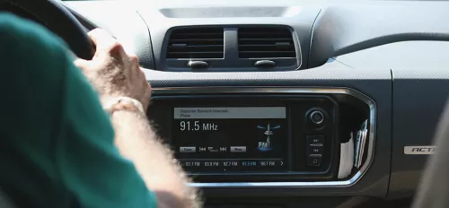 Ein Auto von innen mit Fahrer, Blick aufs Autoradio