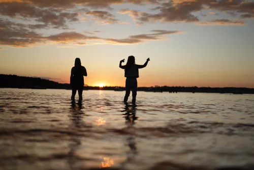 Zwei Menschen bei Sonnenuntergang im Wasser