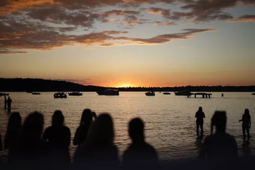 Menschen am Strand bei Sonnenuntergang